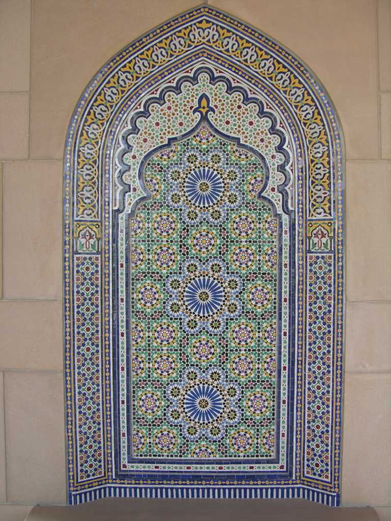 Muscat 04 Grand Mosque 09 Decorated Arch Each niche in the cloister contains a decorated arch. A brass plaque indicates that the style of the mosque is based on that of Tamurlane and the mosque of Samarkand. The decorations are styled on a combination of Chinese and Islamic designs.